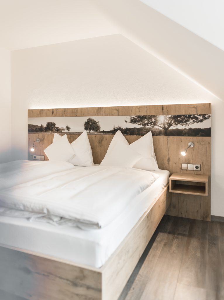 Schlafzimmer der Feriensuite im Landhotel Waldeck in Fremdingen mit Doppelbett und modernem Holzinterieur