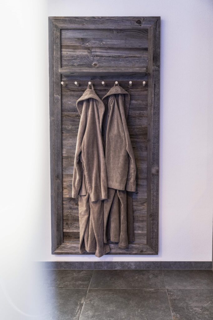 Wellness-Bademäntel an rustikaler Holzwand